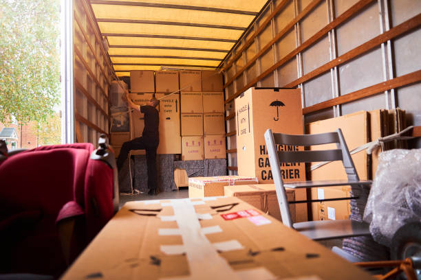 Two movers lifting a couch during an apartment move in Al Majaz Sharjah